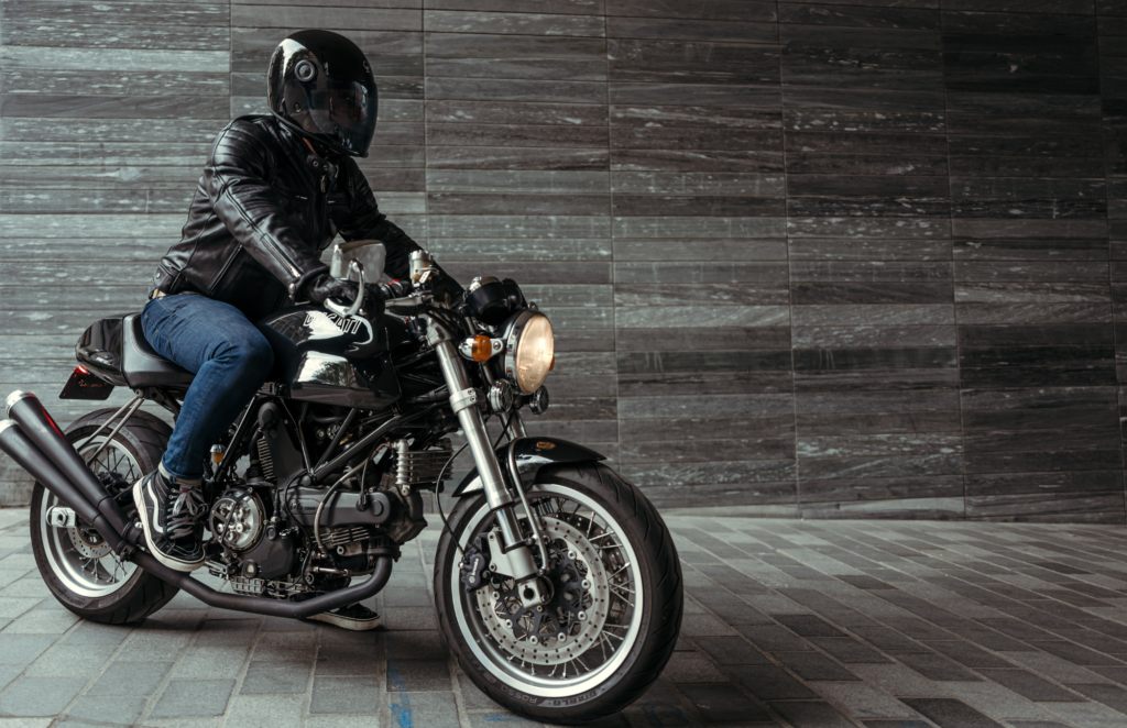 Motard équipé d'un casque de moto sur la route